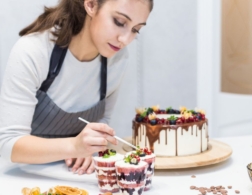 Photo of a confectionery chef placing decoration on top of dessert cups